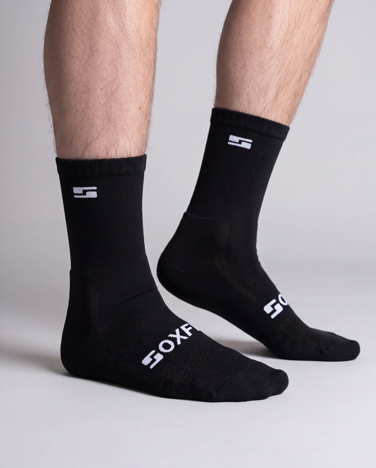 Men's black crew socks worn, side view showing the white S logo and SOXFIX wordmark
