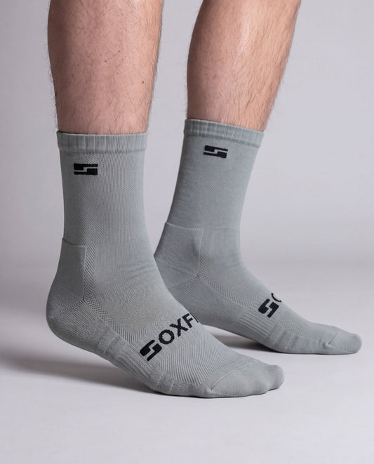 Men's grey crew socks worn, side view showing the S logo and SOXFIX wordmark