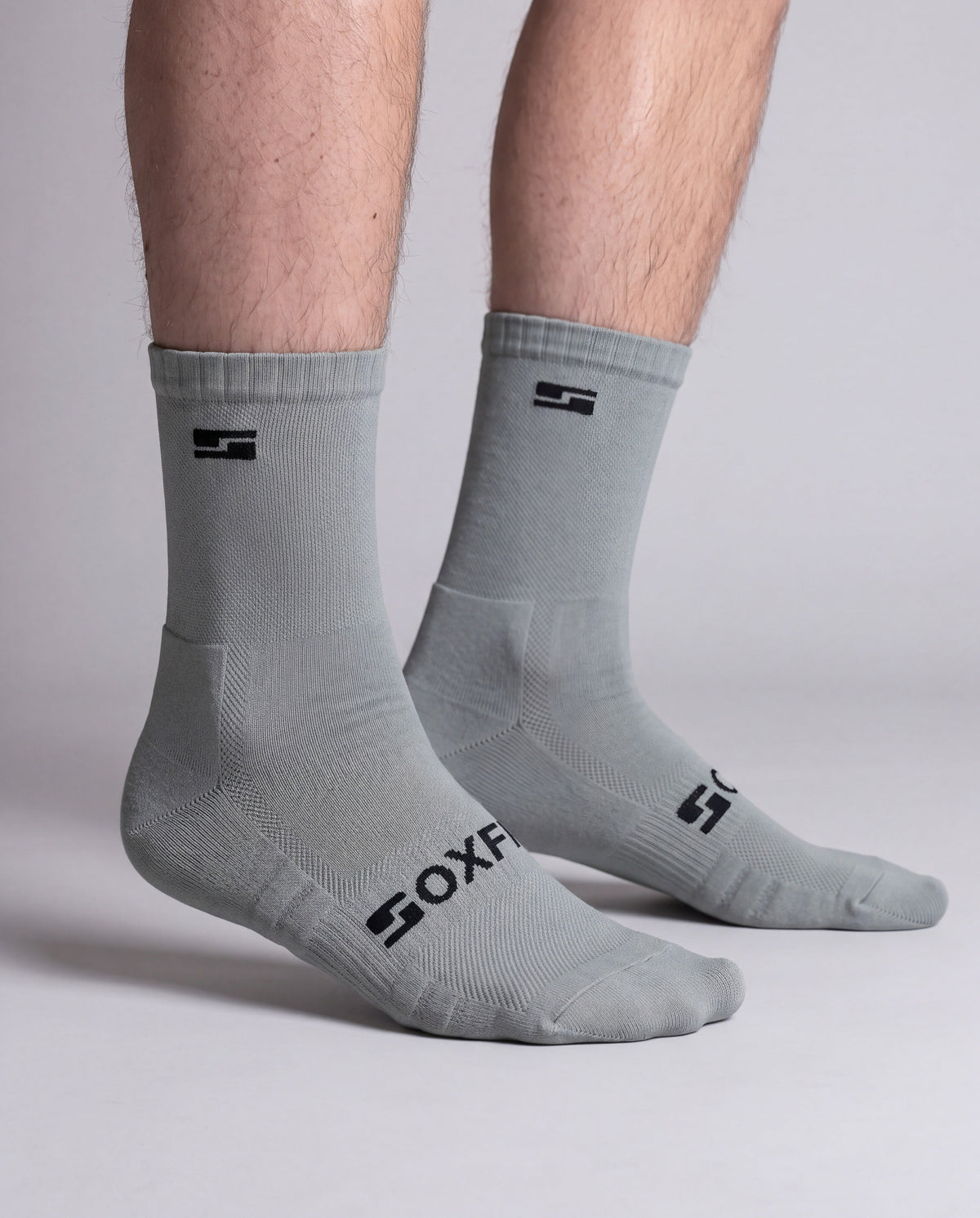 Men's grey crew socks worn, side view showing the S logo and SOXFIX wordmark