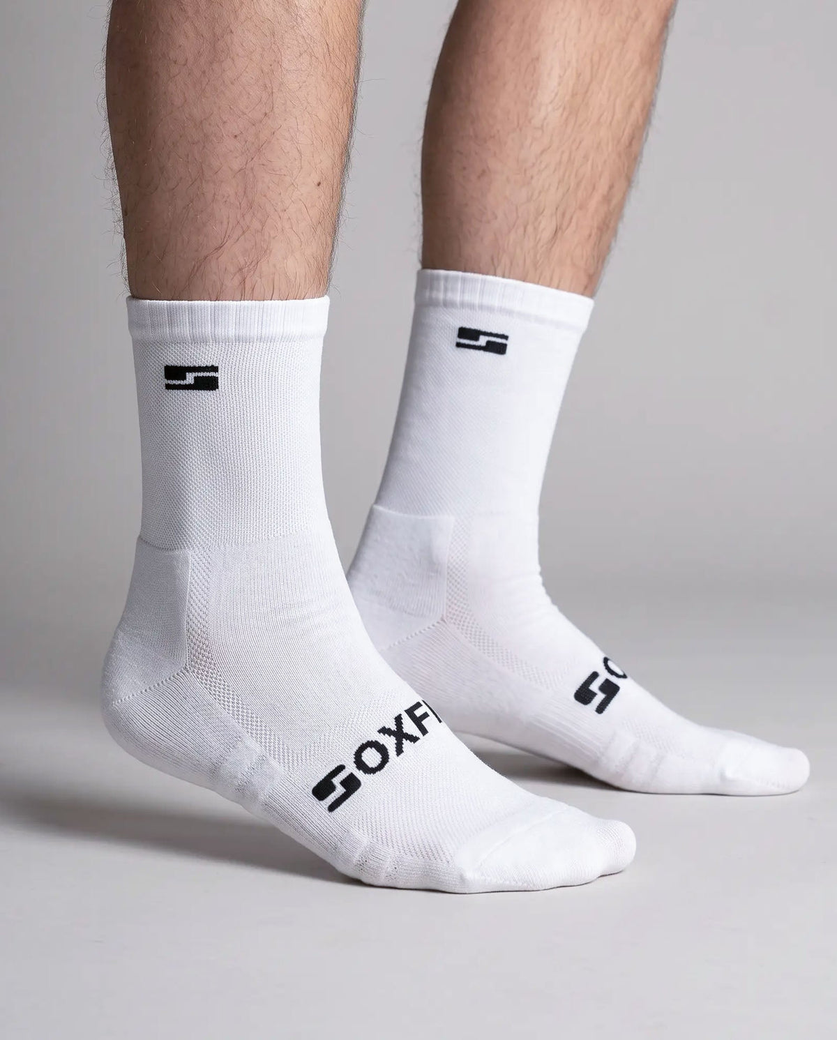 Men's white crew socks worn, side view showing the S logo and SOXFIX wordmark
