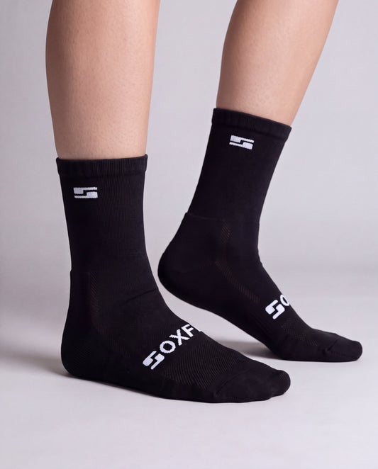 Women's black crew socks worn, side view showing the white S logo and SOXFIX wordmark
