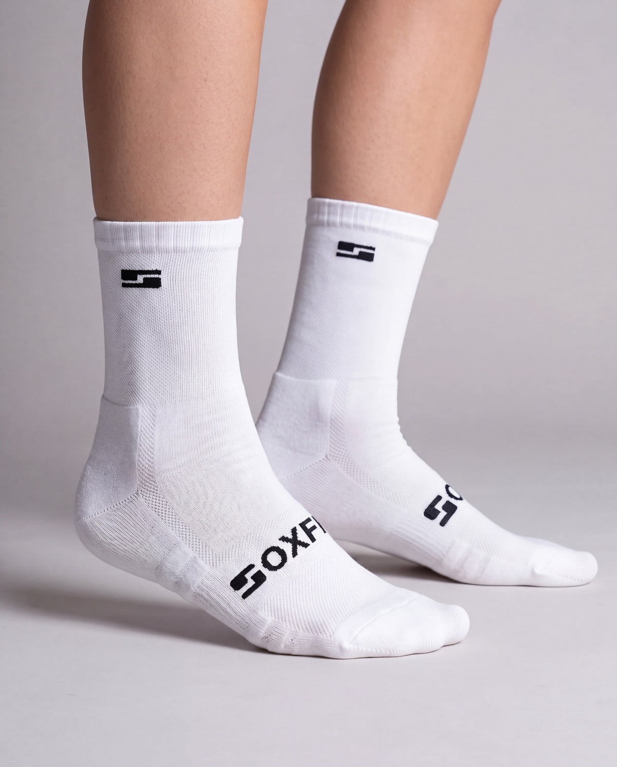 Women's white crew socks worn, side view showing the S logo and SOXFIX wordmark